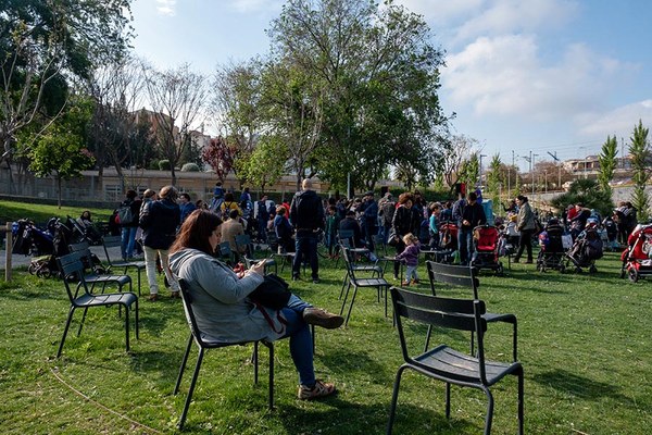 Photo of resident inside green park sat on chair while on phone